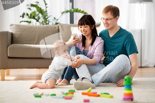 Image of happy family with baby boy at home