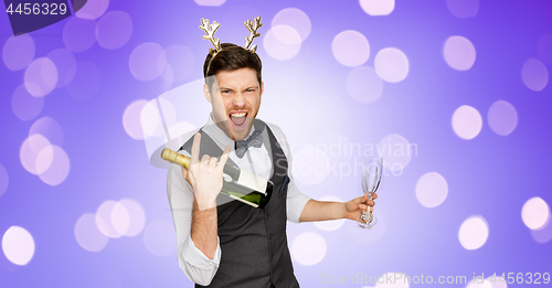 Image of man with bottle of champagne at christmas party