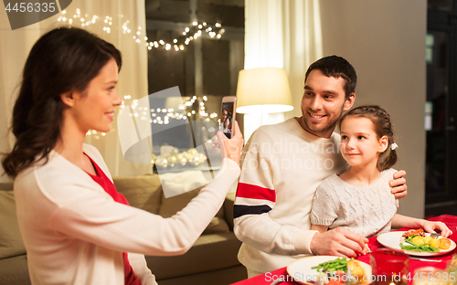 Image of happy family taking picture at christmas dinner
