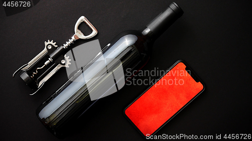 Image of Red wine bottle, corkscrew and boxed christmas gift