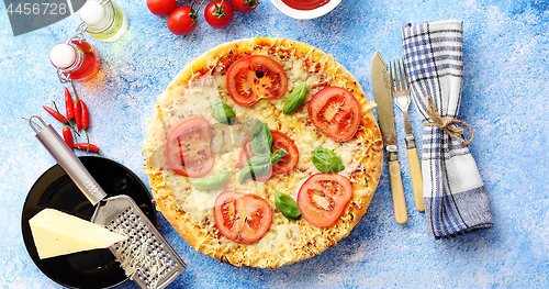 Image of Delicious italian pizza served on blue stone table, shot from above