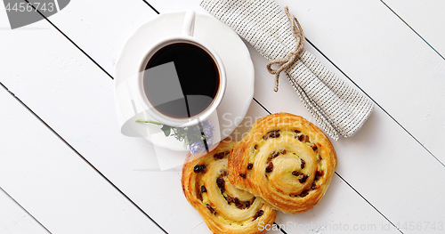 Image of Delicious pastry with raisins and a cup of coffee top view.