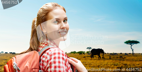 Image of happy woman with backpack over african savannah