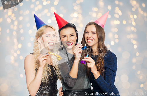 Image of happy women with party hats hugging