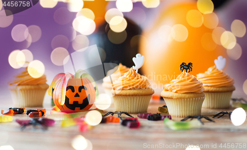 Image of halloween party decorated cupcakes on wooden table