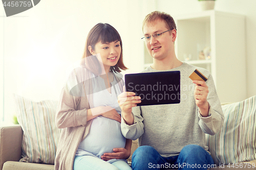 Image of husband and pregnant wife shopping online at home