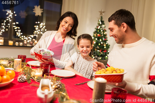 Image of happy family having christmas dinner at home