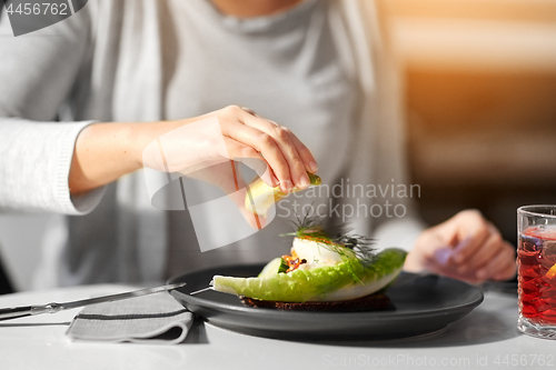 Image of woman eating caviar salad at cafe or restaurant