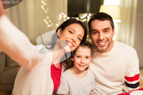 Image of happy family taking selfie at christmas