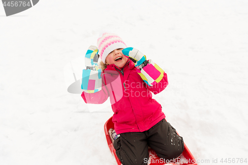 Image of happy little girl on sled outdoors in winter