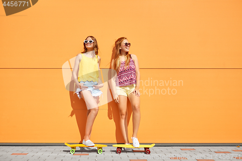 Image of teenage girls with short skateboards outdoors