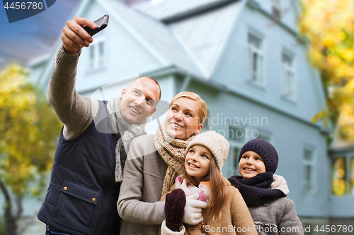 Image of family takes autumn selfie by cellphone over house