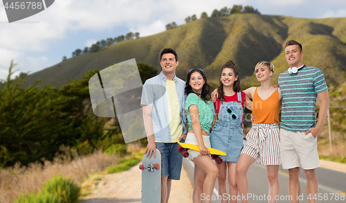 Image of friends with skateboards over big sur hills