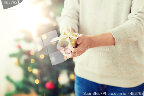 Image of close up of man with christmas gift at home