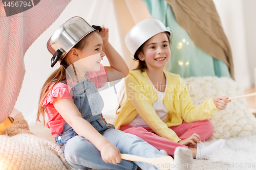 Image of girls with kitchenware playing in tent at home