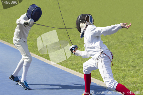Image of Two young man fencing athletes fight 