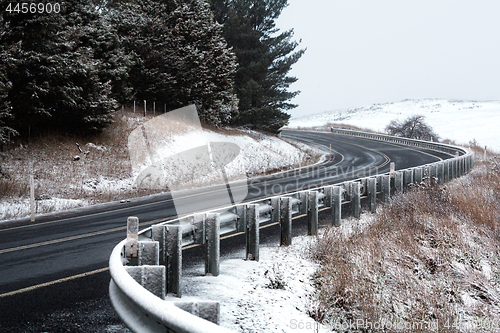 Image of Curving road through snow covered hills