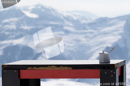 Image of Old table with sugar bowl in outdoor cafe at ski resort