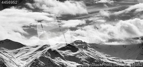 Image of Black and white panoramic view on snow sunlight mountains and cl