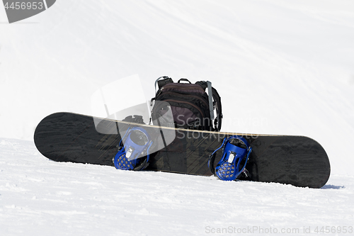 Image of Snowboard and backpack on ski slope