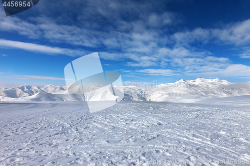 Image of Ski slope, snow mountains and blue sky with clouds