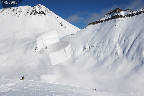 Image of Two skiers and off-piste slope with traces of skis, snowboards a