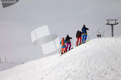 Image of Skiers before downhill on off-piste slope and overcast misty sky