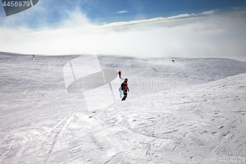 Image of Skiers and snowboarders downhill on snow slope