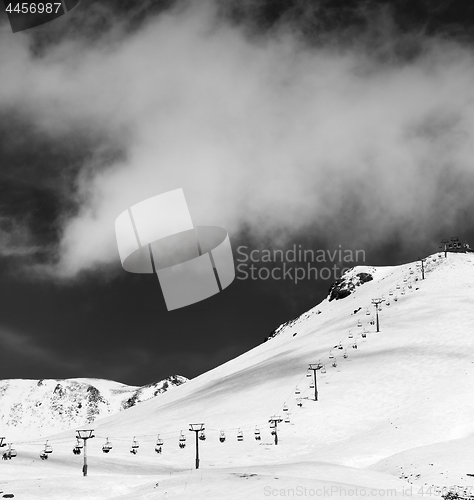 Image of Black and white view on chair-lift and ski slope in sun day