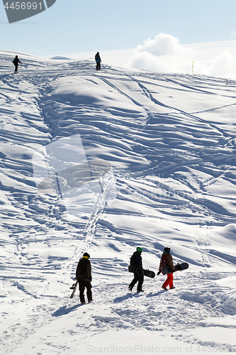 Image of Snowboarders on footpath in snow at sun morning