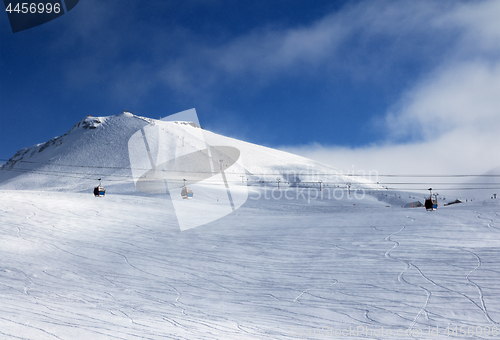 Image of Gondola and chair lifts on ski resort at winter evening with sno