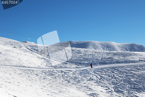 Image of Skier downhill on ski slope at nice sun morning