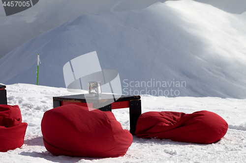 Image of Bean bag chairs and table in outdoor cafe at ski resort 