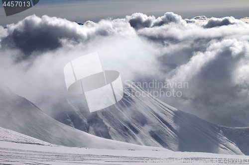 Image of Ski slope and mountains in sunlight storm clouds before snowfall