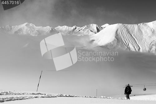 Image of Black and white view on off-piste slope with snowboarder and mou