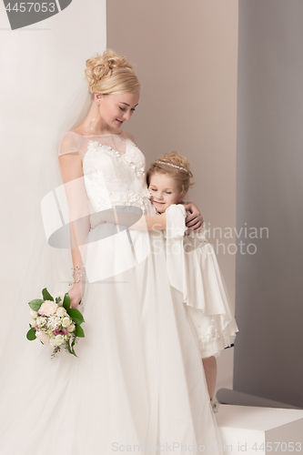 Image of Little pretty girls with flowers dressed in wedding dresses