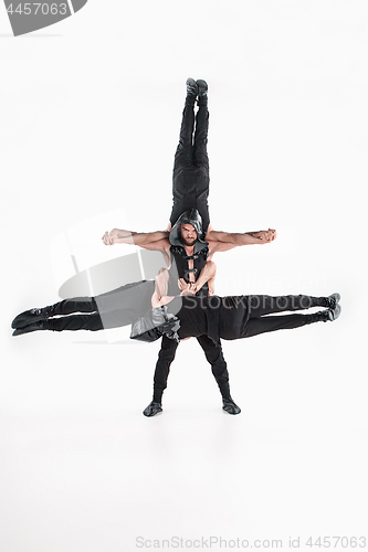 Image of The group of gymnastic acrobatic caucasian men on balance pose