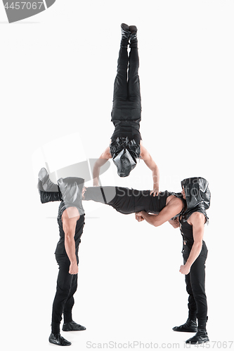 Image of The group of gymnastic acrobatic caucasian men on balance pose