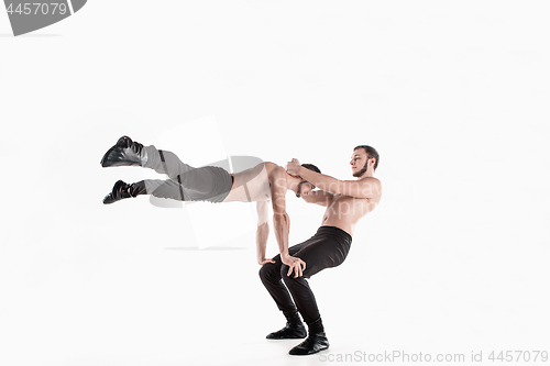 Image of The group of gymnastic acrobatic caucasian men on balance pose