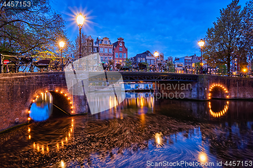 Image of Amterdam canal, bridge and medieval houses in the evening