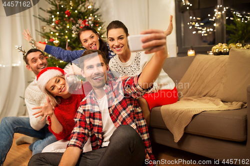 Image of friends celebrating christmas and taking selfie