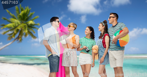 Image of happy friends with beach and summer accessories