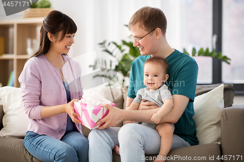 Image of happy family with gift and baby boy at home