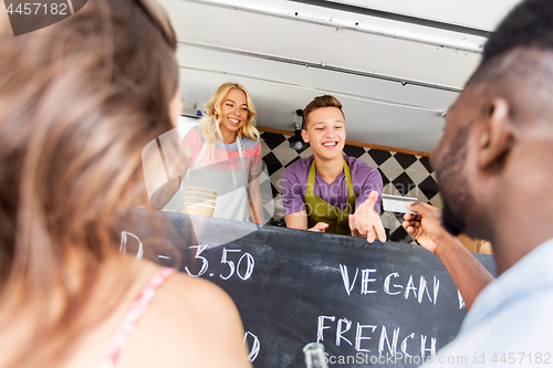 Image of customers giving credit card at food truck seller