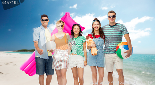 Image of happy friends with beach and summer accessories