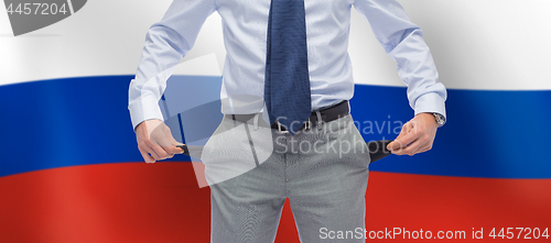 Image of businessman with empty pockets over flag of russia