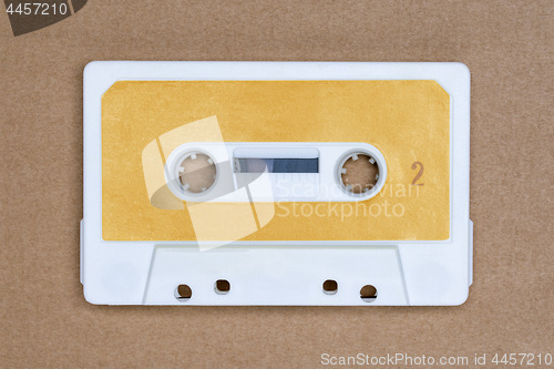 Image of Retro white audio tape with yellow label on brown background. Side 2.