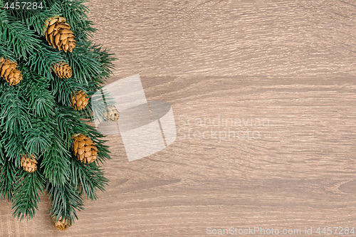 Image of Christmas tree on brown wooden texture background.