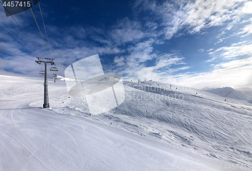 Image of Ski slope, chair-lift on ski resort and blue sky with sunlight c