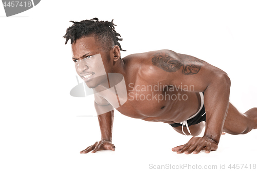 Image of Muscular young man doing press-ups